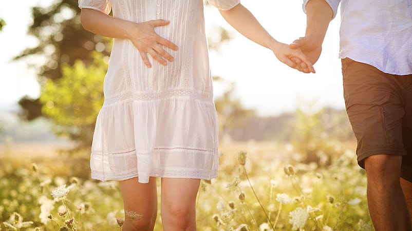 pareja agarrada de la mano y mano tocando tripa embarazo