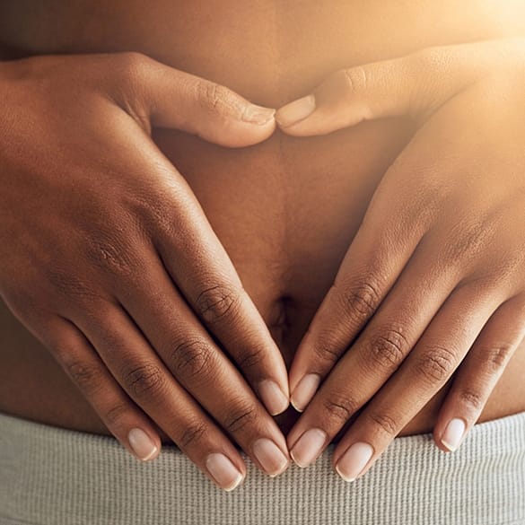 Kvinna med händerna på magen