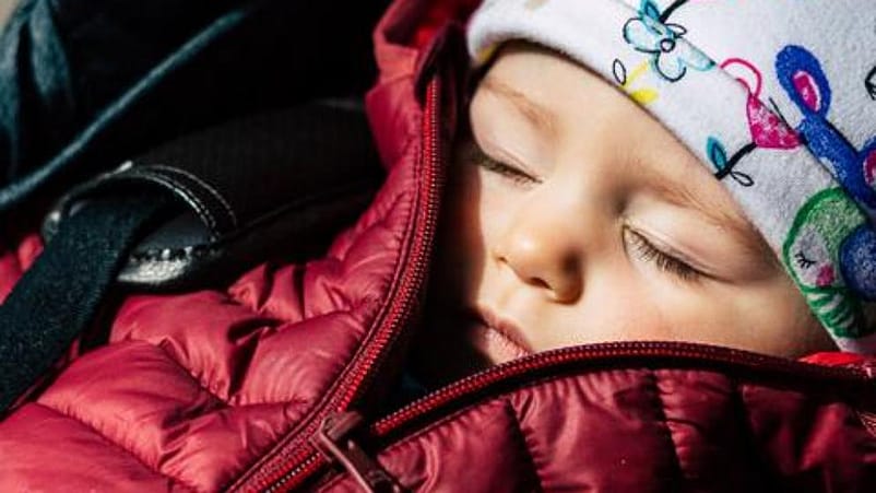 bebé dormido con un abrigo y gorrito puesto