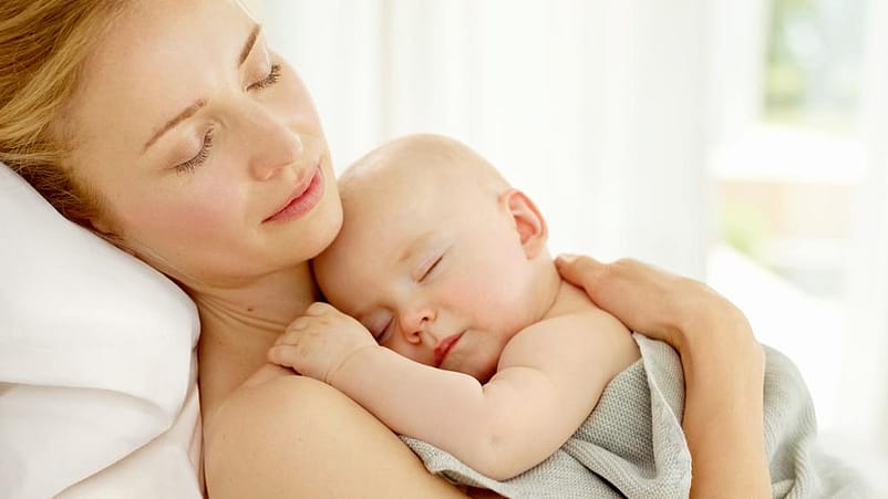 mujer piel con piel con bebe en brazos