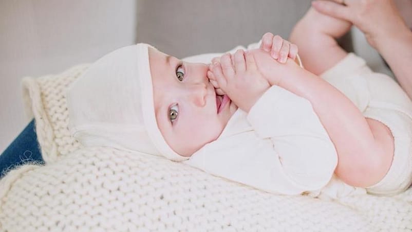 bebé tumbado jugando con su pie