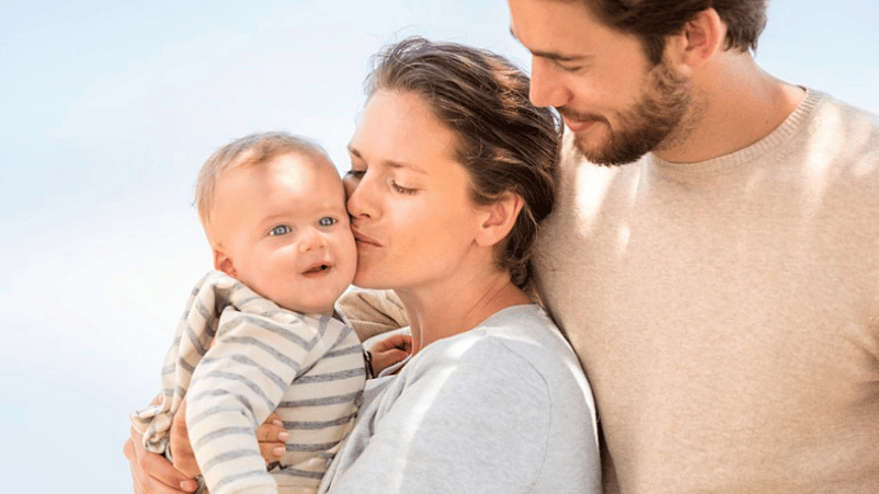 mujer y hombre con un bebé en brazos