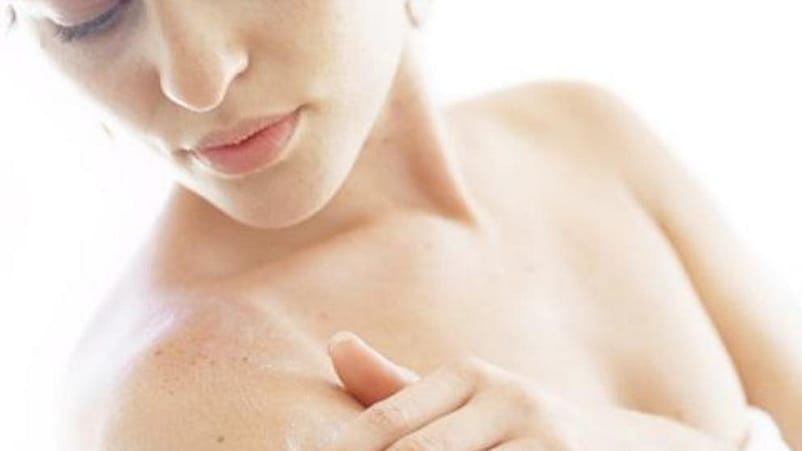 femme qui s'applique de la crème sur le bras