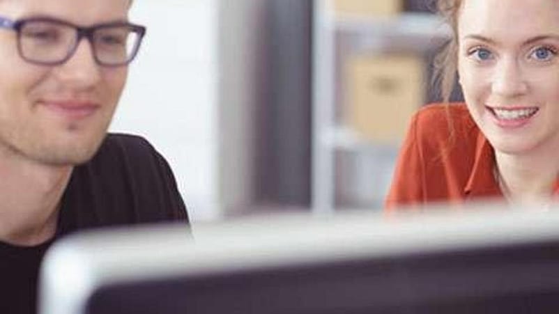 deux personnes devant un écran ordinateur