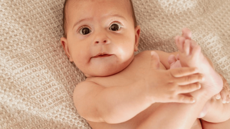 bebé tumbado agarrándose el pie