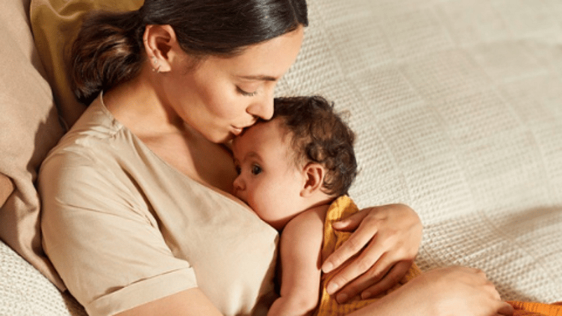 mujer abrazando a un bebé dormido que sostiene en los brazos
