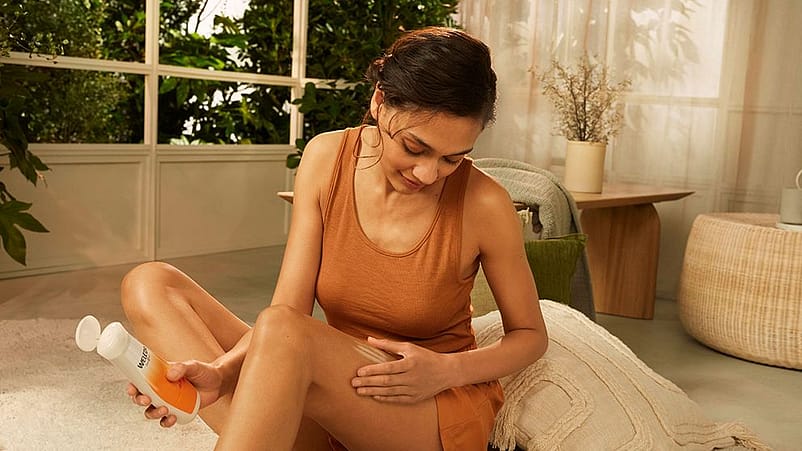 Donna applica la crema sulle sue cosce