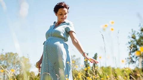 mujer embarazada feliz en el campo
