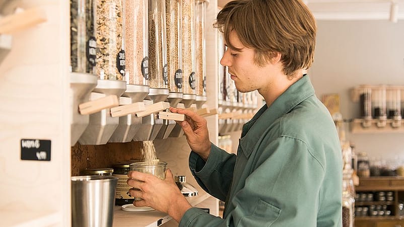 Un ragazzo preleva da alcuni contenitori del cibo