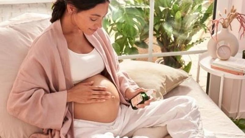 mujer embarazada aplicandose aceite antiestrias de weleda
