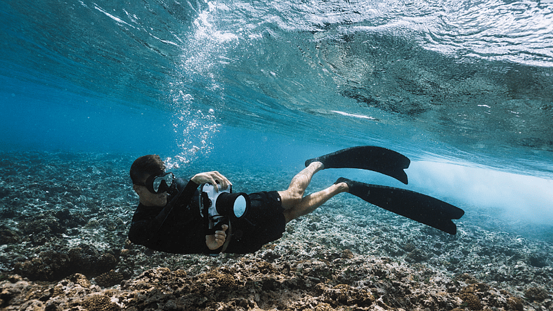 hombre haciendo apnea en el mar con camara acuatica