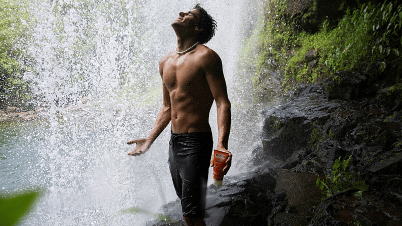 hombre en mitad de la naturaleza con una cascada en el fondo