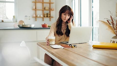 Frau trinkt Kaffee am Computer