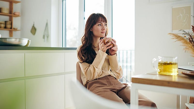 Frau macht eine Pause im Sessel mit einem Tee