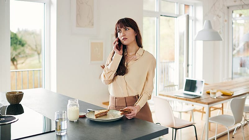 Frau stehend am Essen und Telefoniert