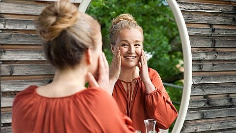 Femme souriante devant le miroir