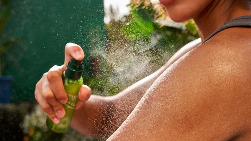 donna che applica lo spray idratante