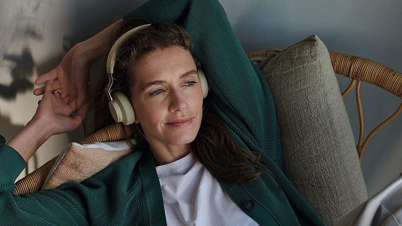 Frau liegt entspannt und hört Musik mit Kopfhörern