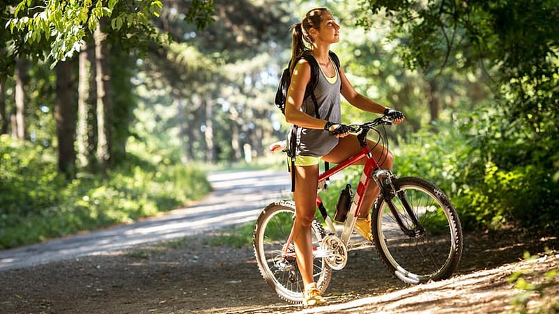 Frau mit Fahrrad im Wald