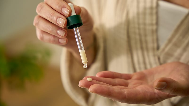 manos con un bote de serum