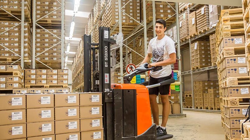 Mann auf Gartenstapler im Lager