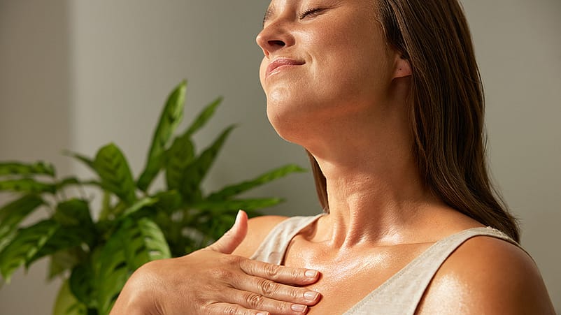 Une femme s'enduit le décolleté d'huile