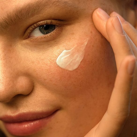 femme avec crème sur le visage