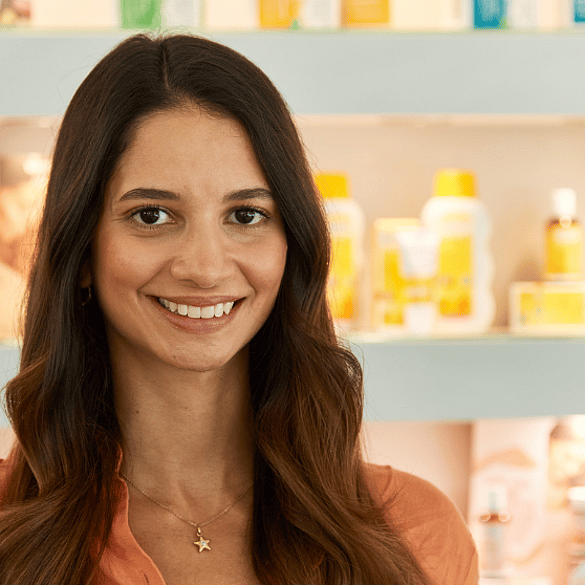 Mitarbeiterin vor Weleda Produkten