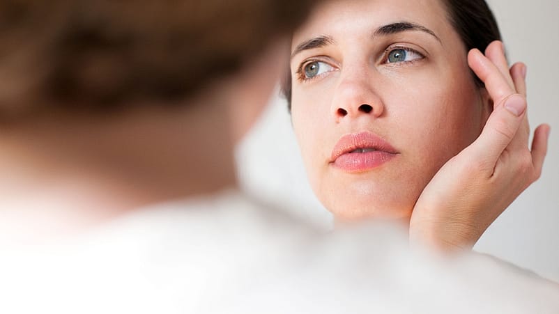 Frau mit Hand am Gesicht