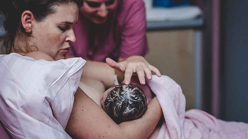 Donna e ostetrica con bambino.