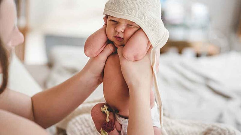 Mutter hält Neugeborenes in die Höhe