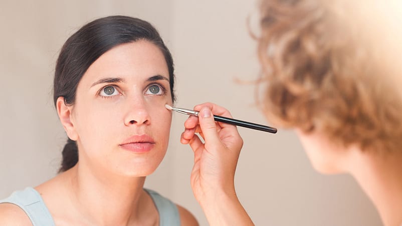 mujer maquillando a otra mujer