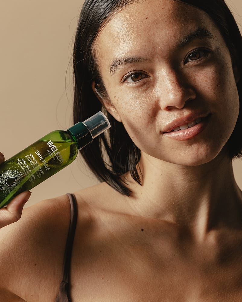 woman holding bottle of body oil