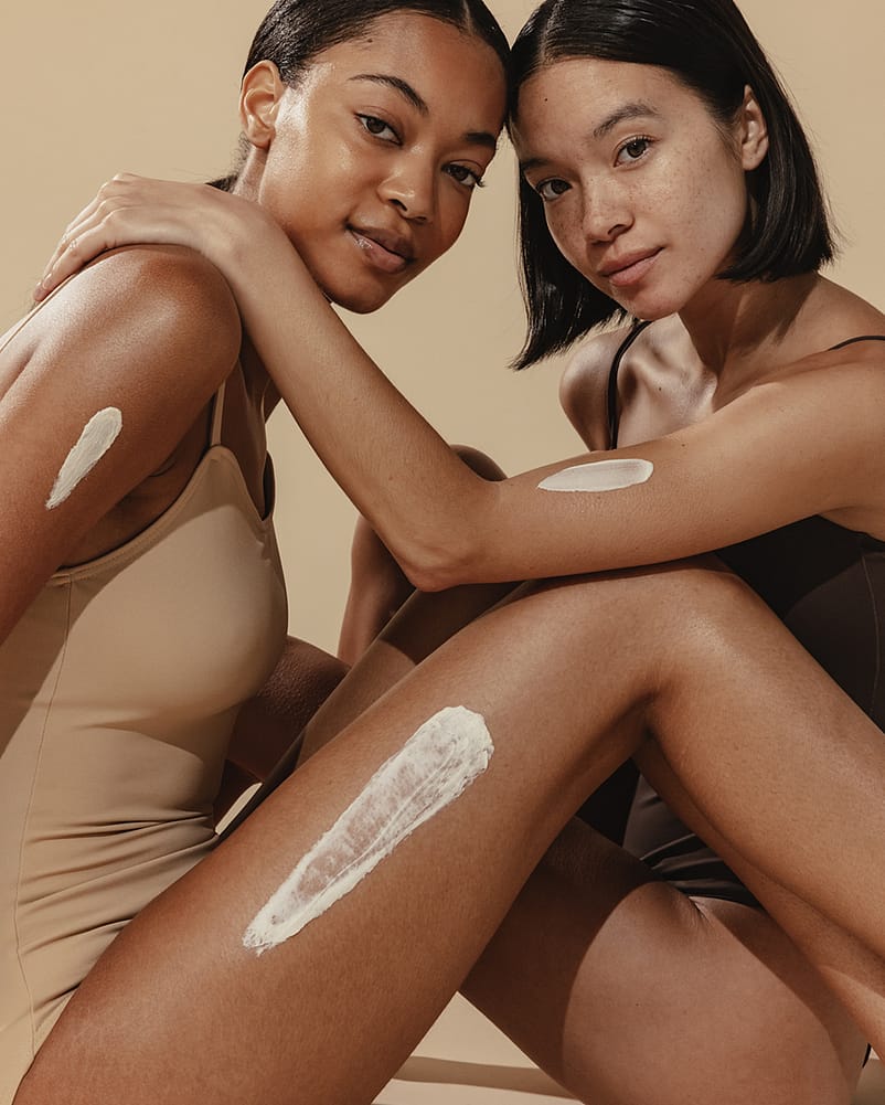 swatches of lotion on two women's legs and arms