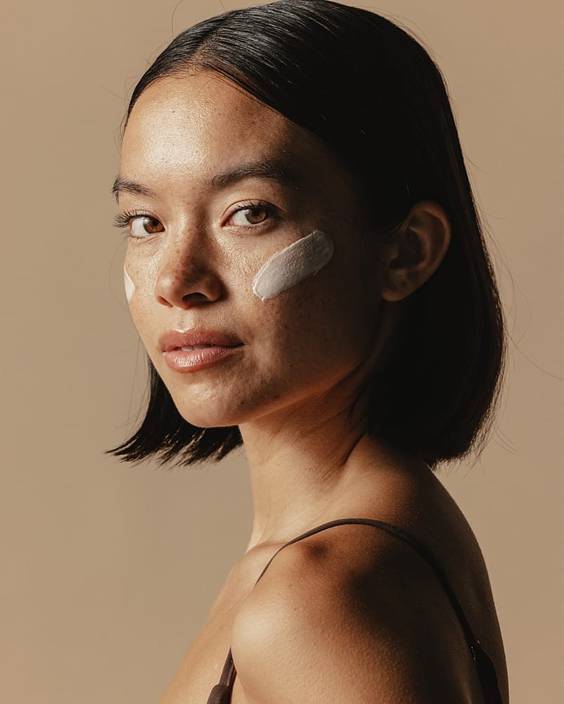 Woman with a moisturizer on cheeks