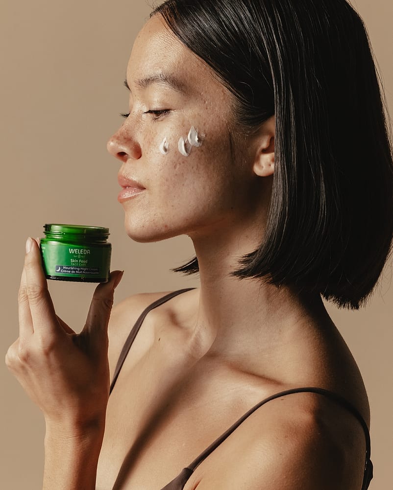 side profile of woman holding night cream