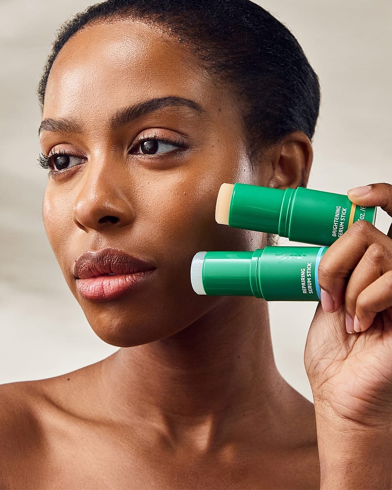 woman holding serum sticks to cheek