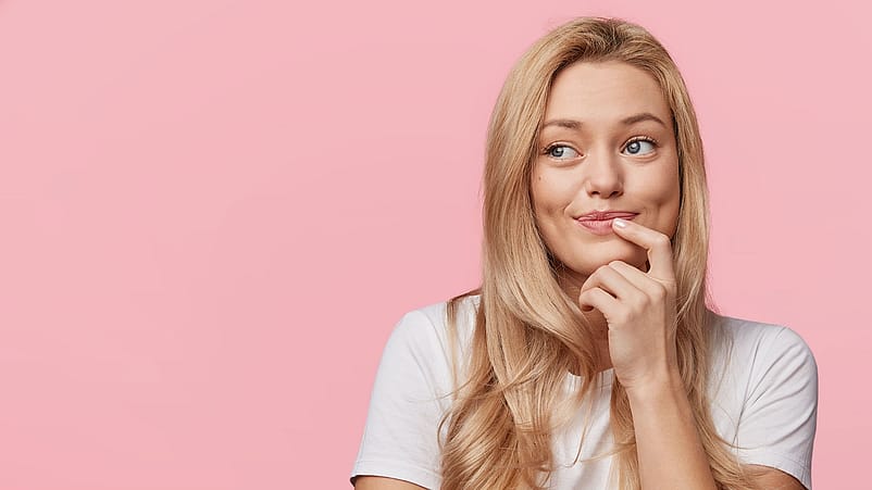 Junge Frau legt ihren Finger an die Lippen