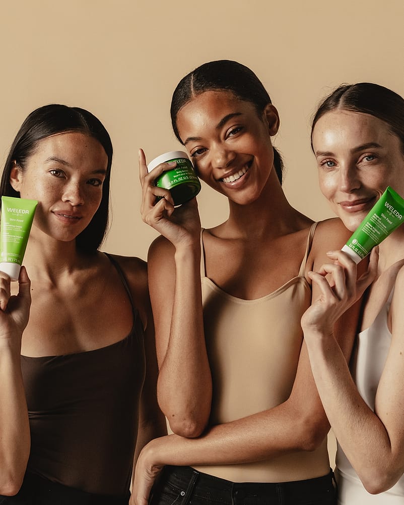 three women holding up skin food products