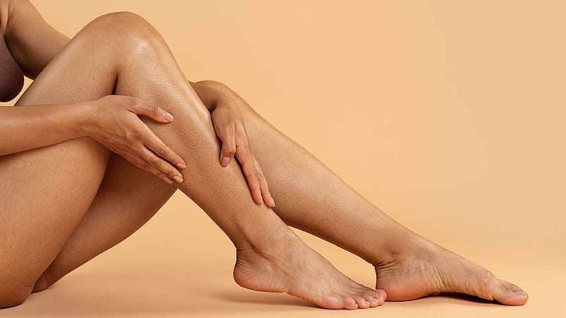 Frau massiert sich die Waden