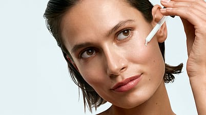 model dropping serum onto cheek