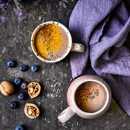 2 tasses de boisson pour dormir, des noix et des myrtilles sur une table