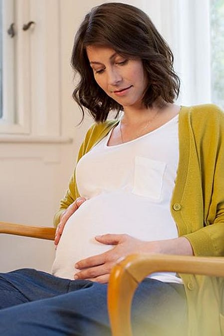 mujer embarazada tocandose la tripa sintiendo al bebe