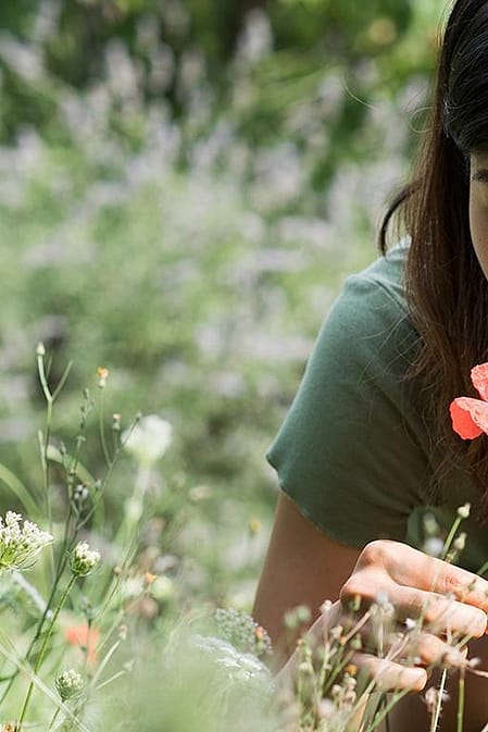 mujer oliendo flores