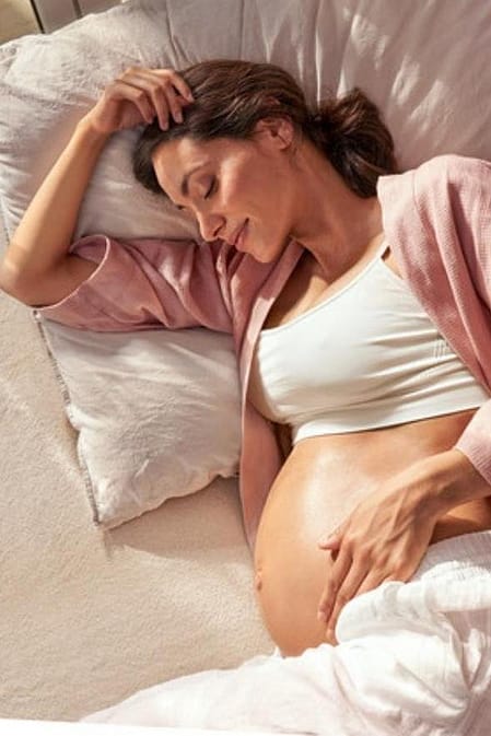 mujer embarazada tumbada en la cama