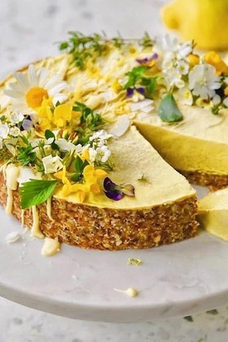 Zitronenkuchen mit Blüten und Zitronen auf einer Platte