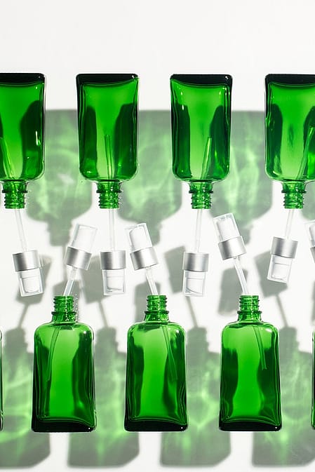 row of green bottles on an assembly line