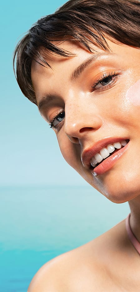 Lächelnde Frau mit Creme im Gesicht