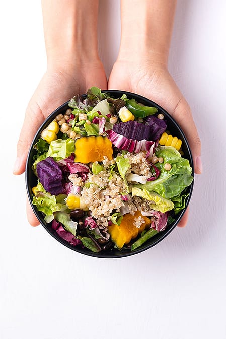 Two women sitting next to eachother and eating.