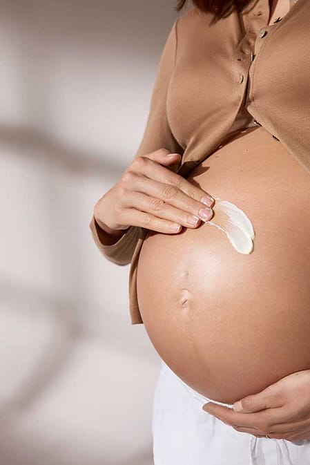 Pregnant woman and partner embracing.